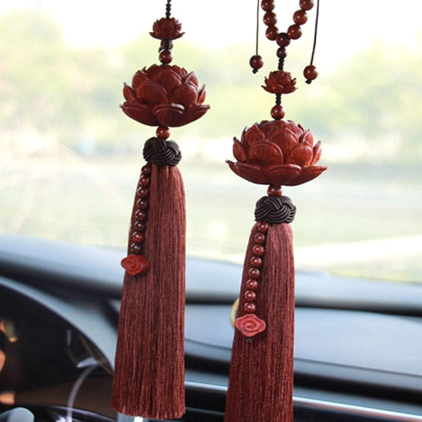Pair of matching red sandalwood lotus car hangings displayed on vehicle dashboard