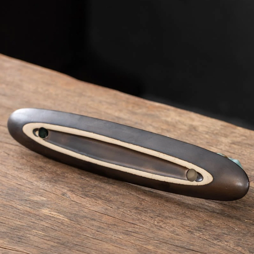 Matte black ceramic elongated incense tray with slot design from Buddhist incense burner set side view