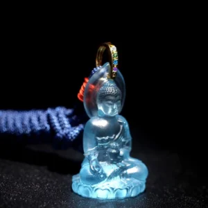 Blue Medicine Buddha Liuli crystal pendant close-up front view showing translucent glass with lotus base and gold bail