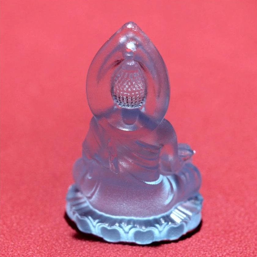 Translucent blue Medicine Buddha pendant close-up highlighting lotus throne base and crystal clarity