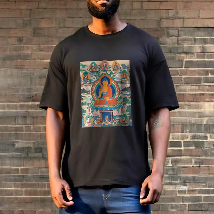 Male model styled in black Medicine Buddha tee against brick backdrop showcasing spiritual artwork