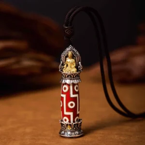 Medicine Buddha Nine-Eye Dzi bead necklace pendant with red-white geometric patterns and gold Buddha ornament, close-up frontal view