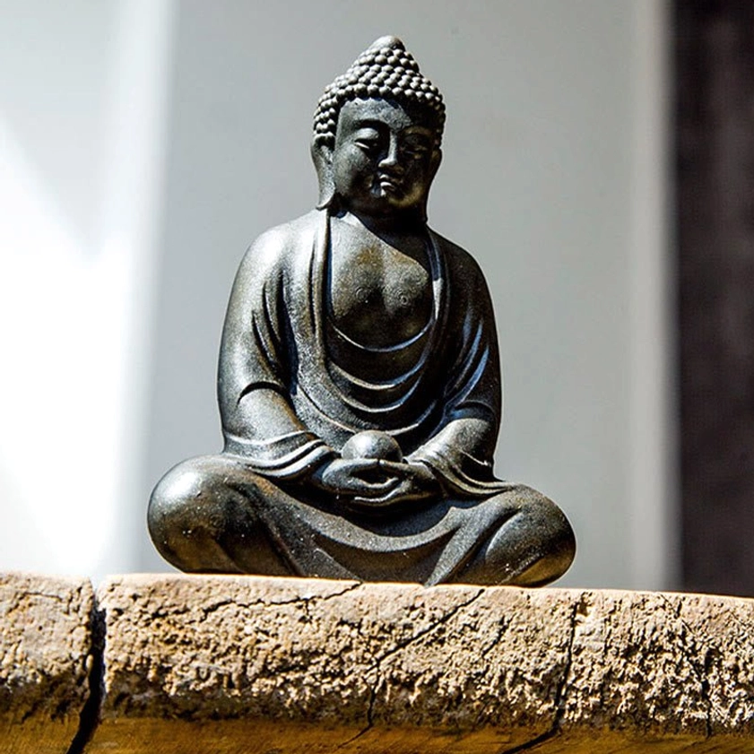Meditating Buddha resin statue displaying weathered craftsmanship and rustic gold-yellow accents
