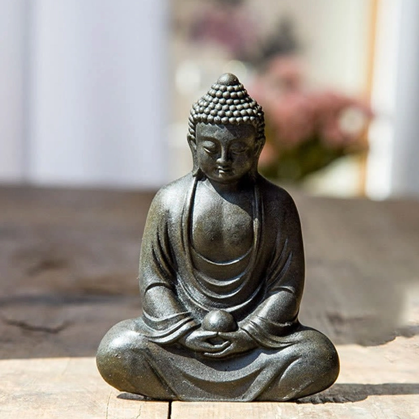 Meditating Buddha statue black finish frontal close-up with hands resting on orb in meditation pose