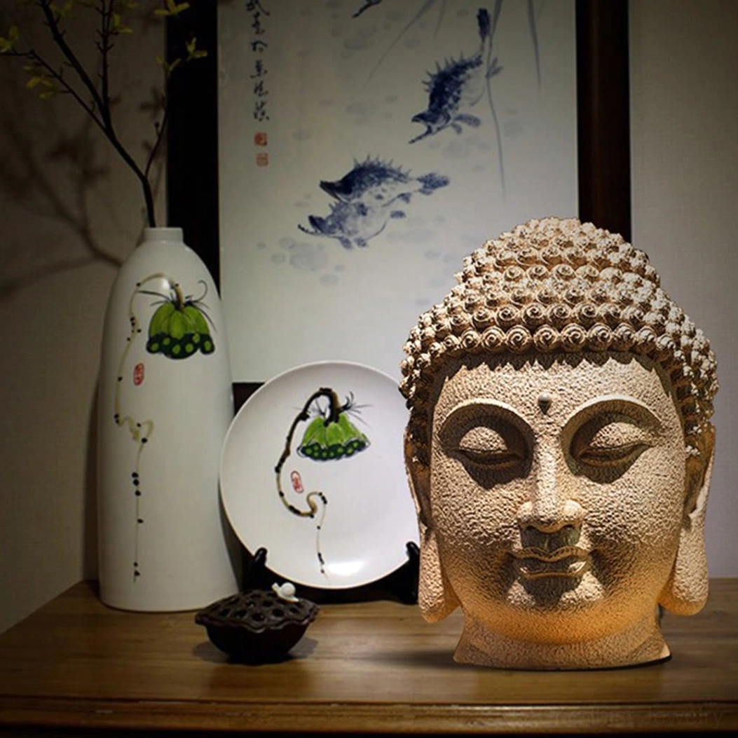 Meditating Buddha head statue displayed in Chinese-style home setting with decorative vase and wall painting