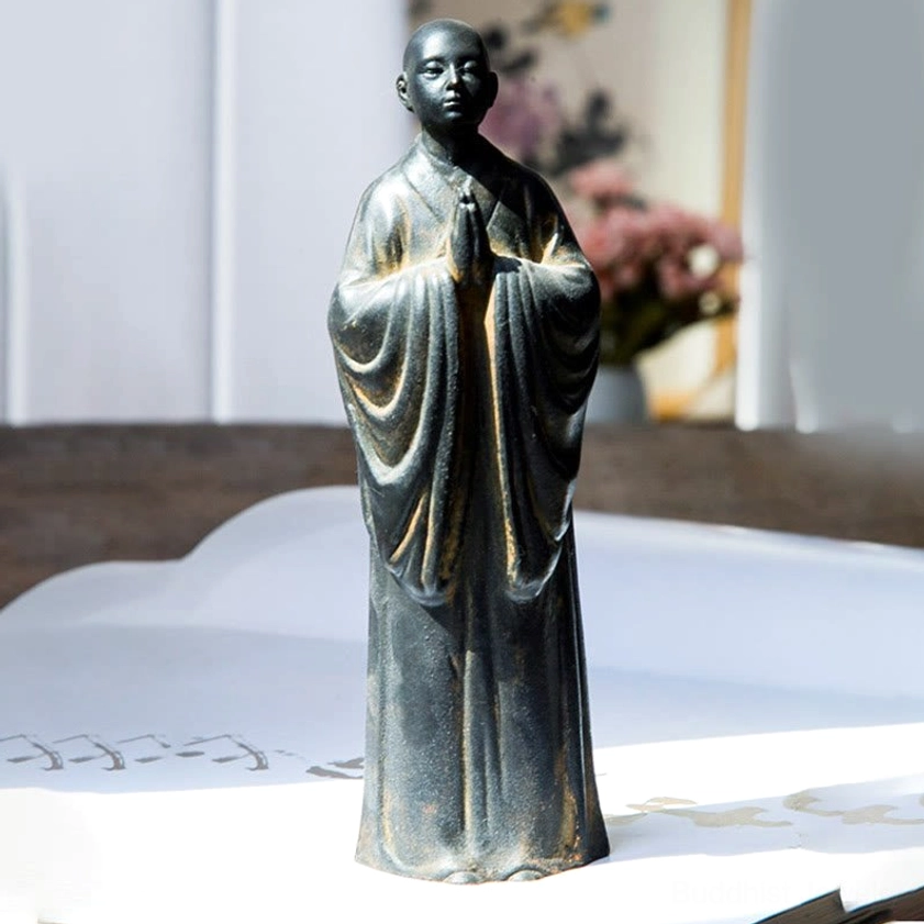 Meditating Monk Statue Close-up - Serene Buddhist Prayer Statue with Golden Details on Wooden Table
