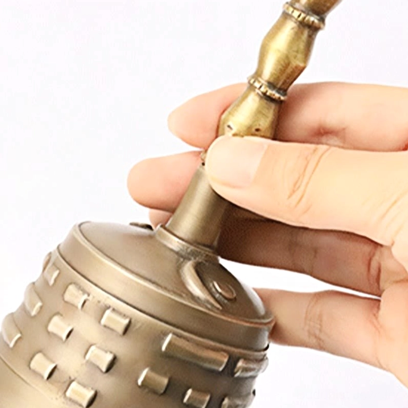 Close-up detail of meditation bell handle with bamboo-carved design and decorative engravings on bell rim