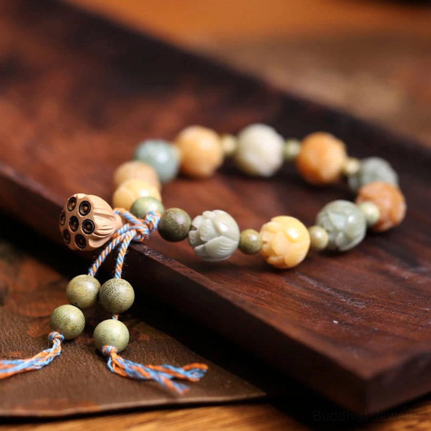 Handmade bodhi seed meditation bracelet with natural tone beads and lotus pendant displayed on dark wooden tray
