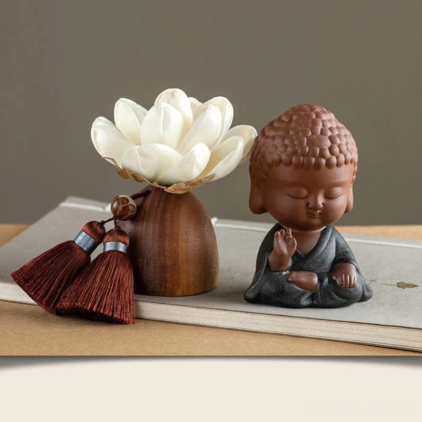 Meditation Buddha in black robe with closed eyes on wooden lotus altar stand with red tassels
