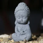 Front view handcrafted sandstone meditation Buddha statue with closed eyes in dark grey matte finish, ideal for mindfulness home decor