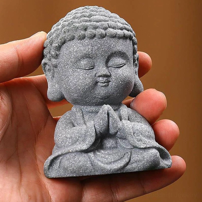 Handheld compact meditation Buddha statue with clasped prayer hands in grey stone finish held in palm