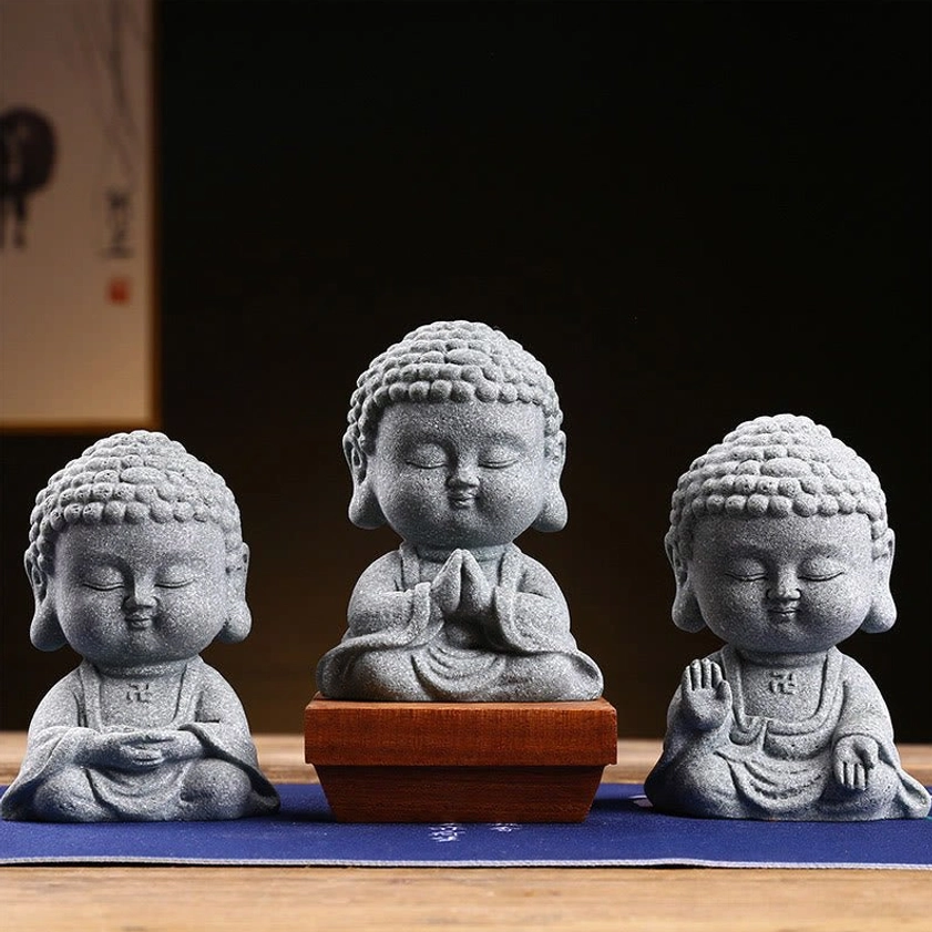Set of 3 handcrafted meditation Buddha statues in grey sandstone with varied sacred postures displayed on wooden tea table