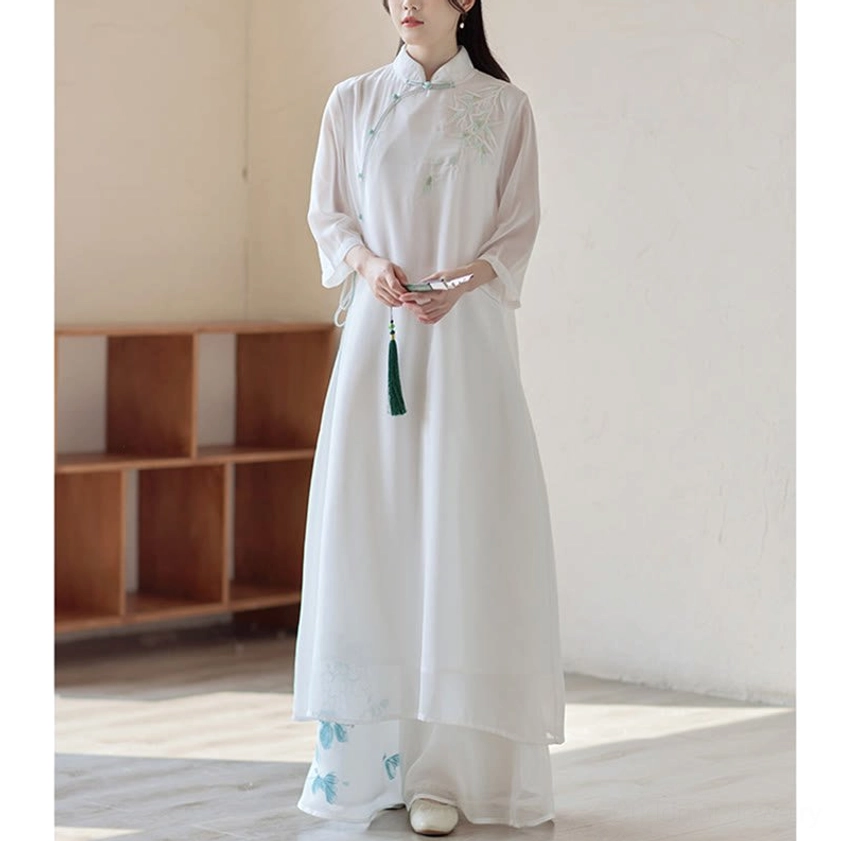 Buddhist-inspired meditation cheongsam dress with wide leg pants, front view showcasing green tassel pendant and blue floral prints on pants