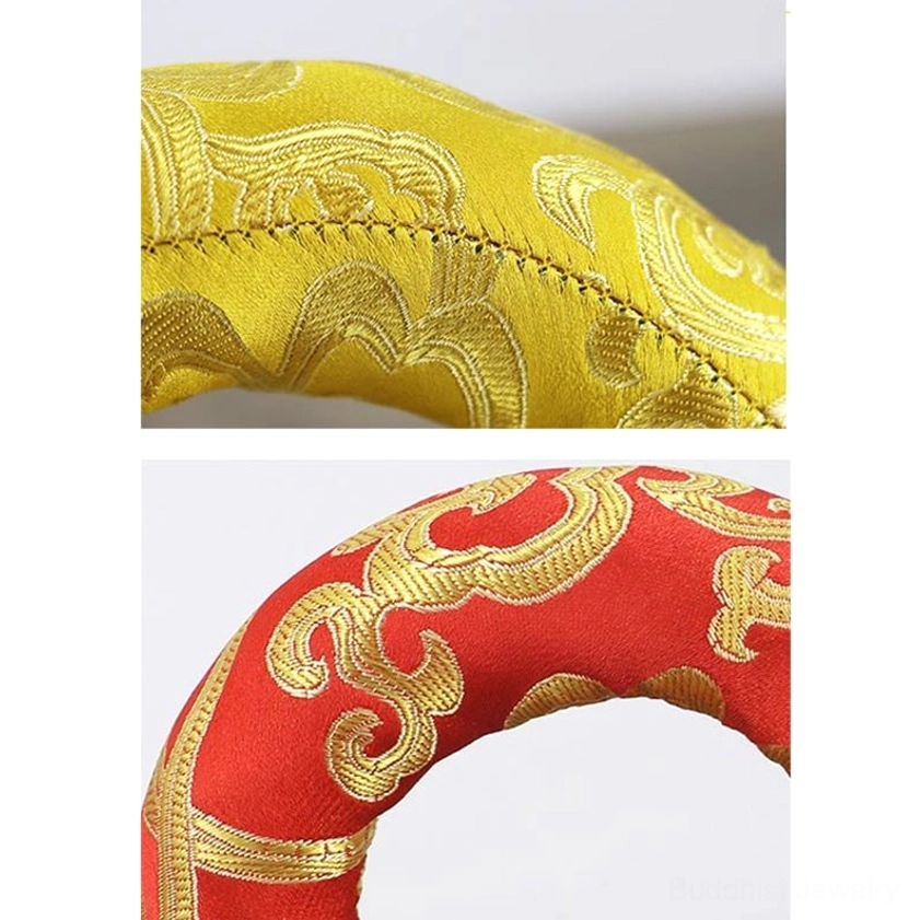 Close-up of yellow brocade singing bowl cushion showing intricate golden cloud embroidery and handcrafted stitching details
