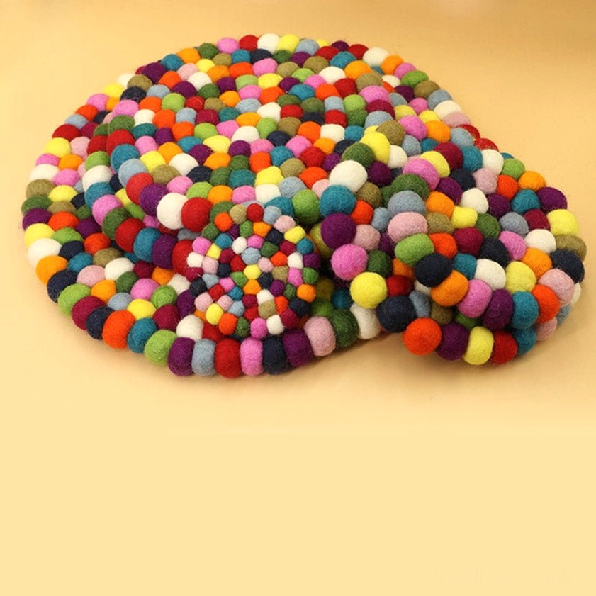 Full round felted wool cushion with mixed-color pom-pom arrangement for sound healing