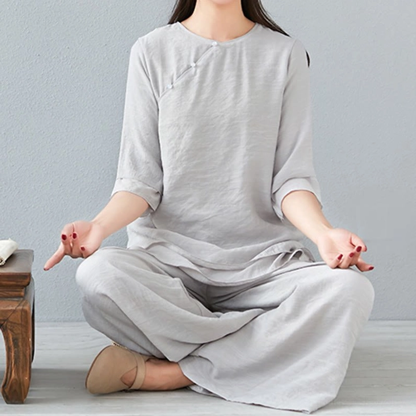 Side profile detail of meditation linen top showing three-quarter sleeve length and loose relaxed fit design