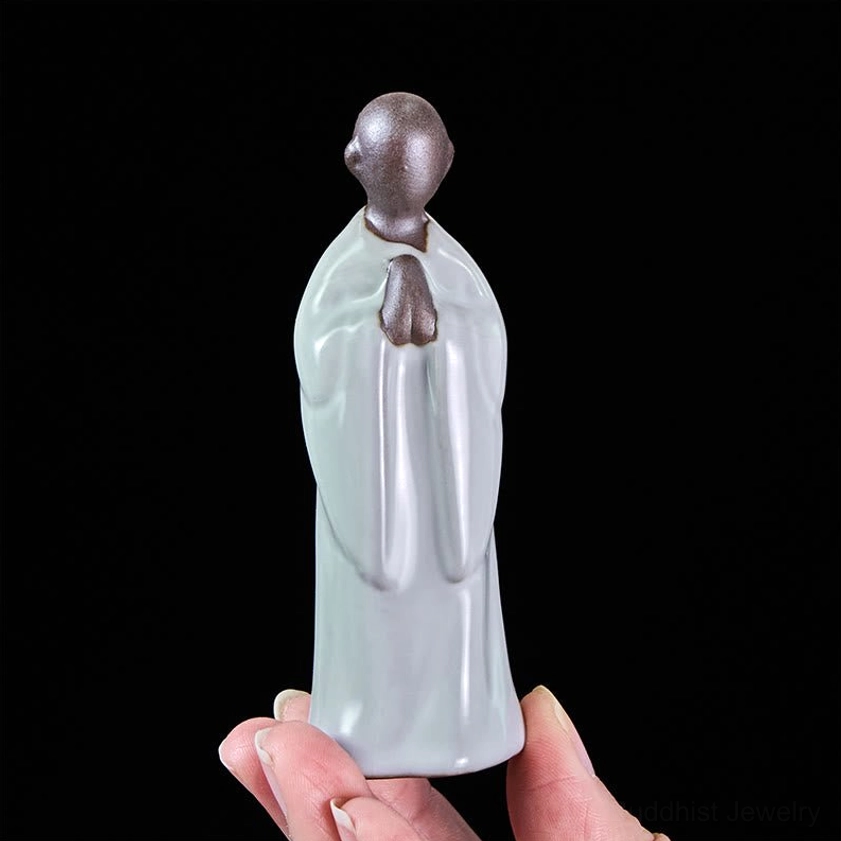 Pale cyan ceramic monk figurine meditating seated posture spiritual decor