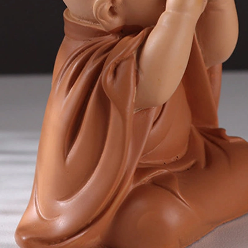 Rear view of meditation monk figurine displaying flowing terracotta resin robe and spiritual craftsmanship