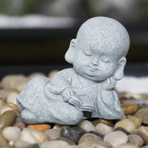 Handcrafted reading monk Buddha statue with natural sandstone finish on pebble stones - miniature zen sculpture