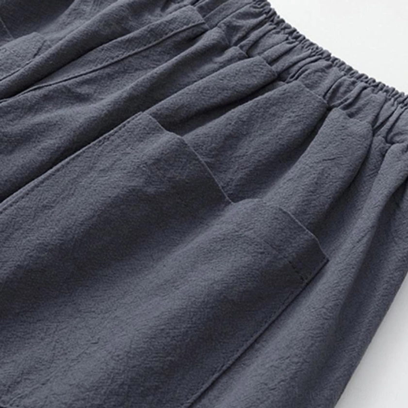 Detail view of Buddhist meditation cropped pants pockets - neatly stitched side pockets in dark gray cotton linen showing quality craftsmanship and functional design