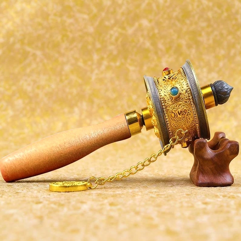 Handcrafted Buddhist prayer wheel with light wood handle and engraved gold body decorated with turquoise and red gemstone inlays
