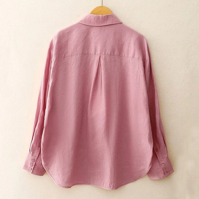 Back view of long-sleeve meditation shirt showing central back pleat and curved hem on mannequin