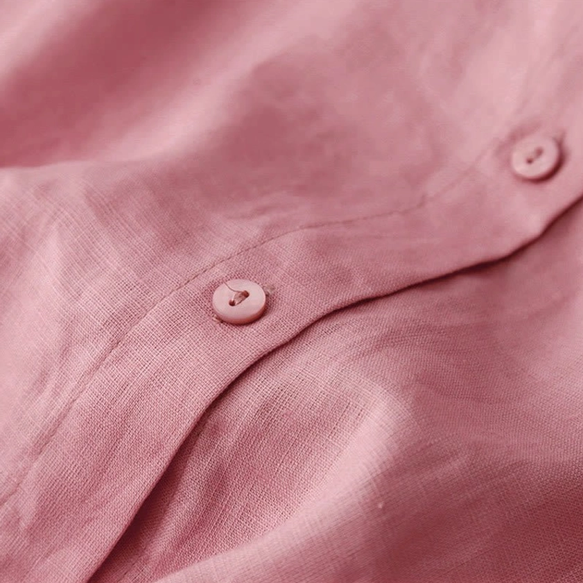 Close-up of meditation shirt cuff showing decorative button detail and soft breathable fabric texture