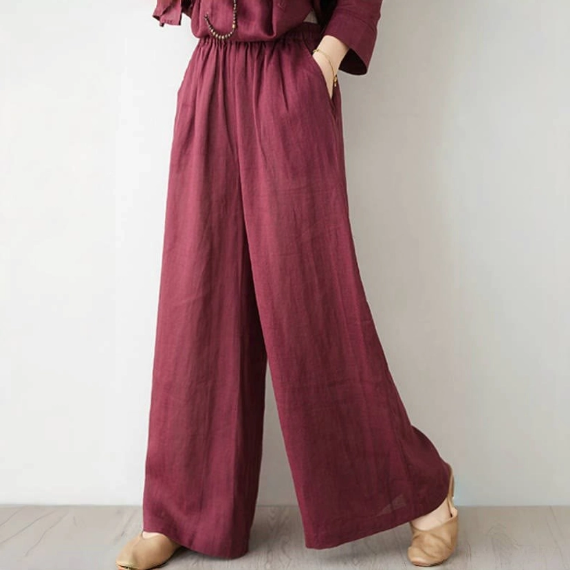 Close-up detail of wide leg pants showing elastic waistband side pocket and burgundy linen texture