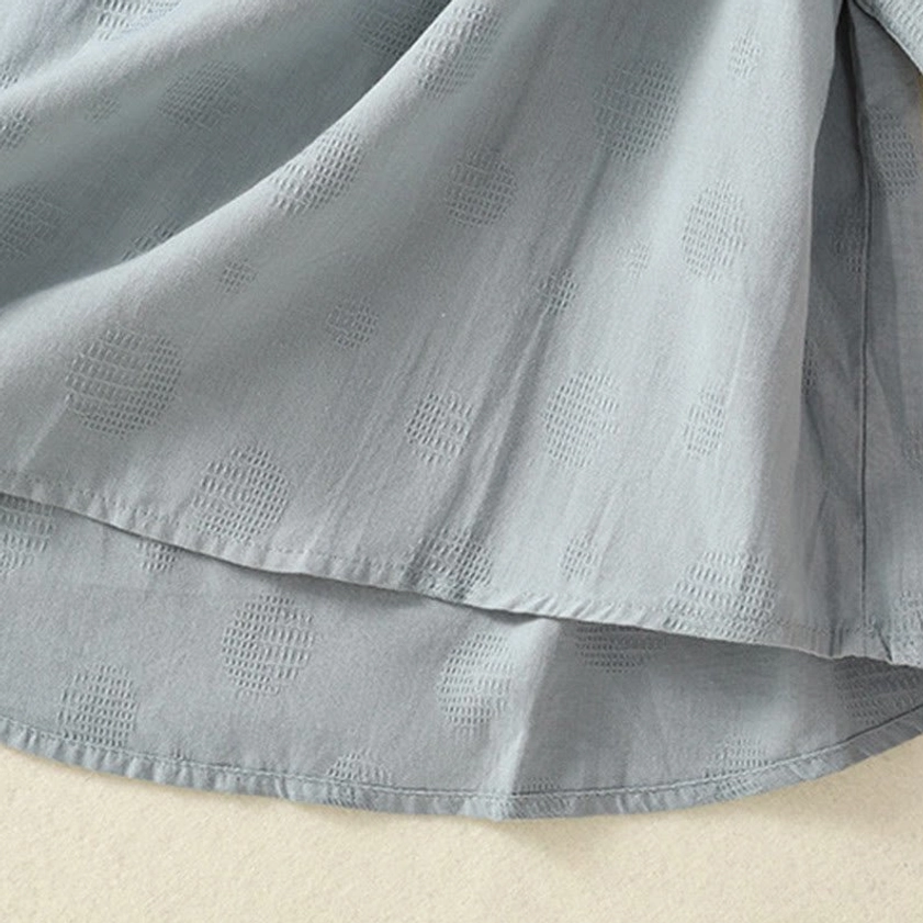 Asymmetric curved hem detail of meditation yoga top - close-up showing unique design and cotton weave