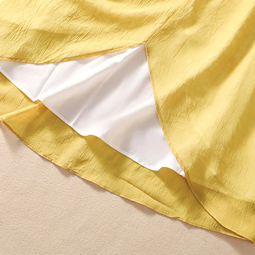 Three-quarter length sleeve detail of meditation tunic showing traditional construction and crinkled yellow fabric texture
