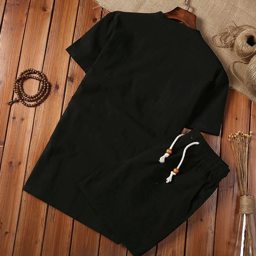 Black henley collar short sleeve top for men's meditation practice, cotton linen fabric close-up