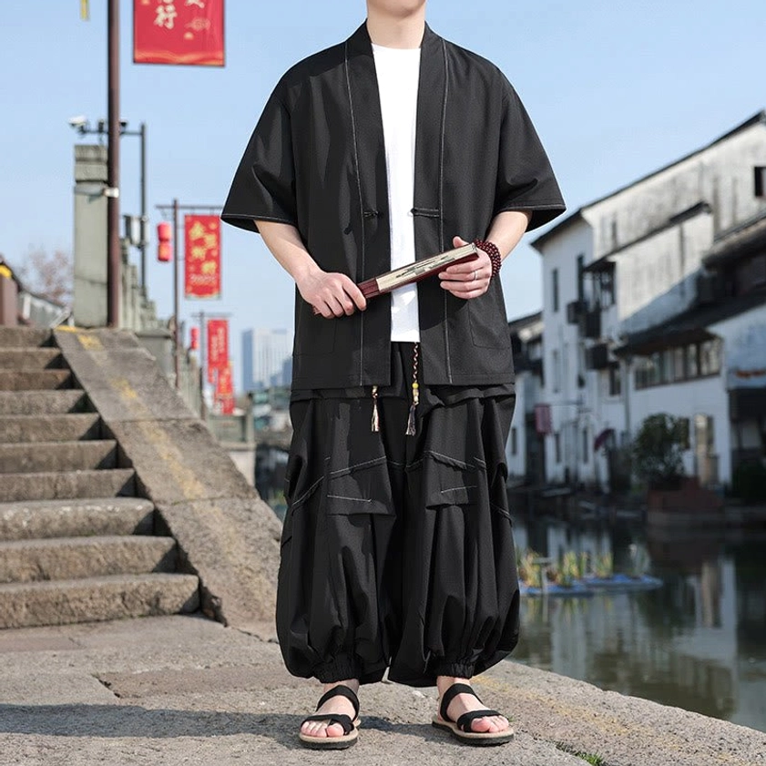 Black kimono set styled with folding fan and traditional woven wrist bracelet, showing versatile wear options