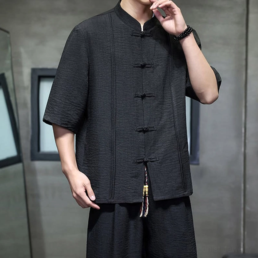 Close-up of men's black meditation suit frog buttons and collar construction detail