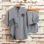 Men's Buddhist meditation linen shirt and shorts set with mandarin collar, frog buttons, and ink-wash landscape print in light gray - front view hanging display