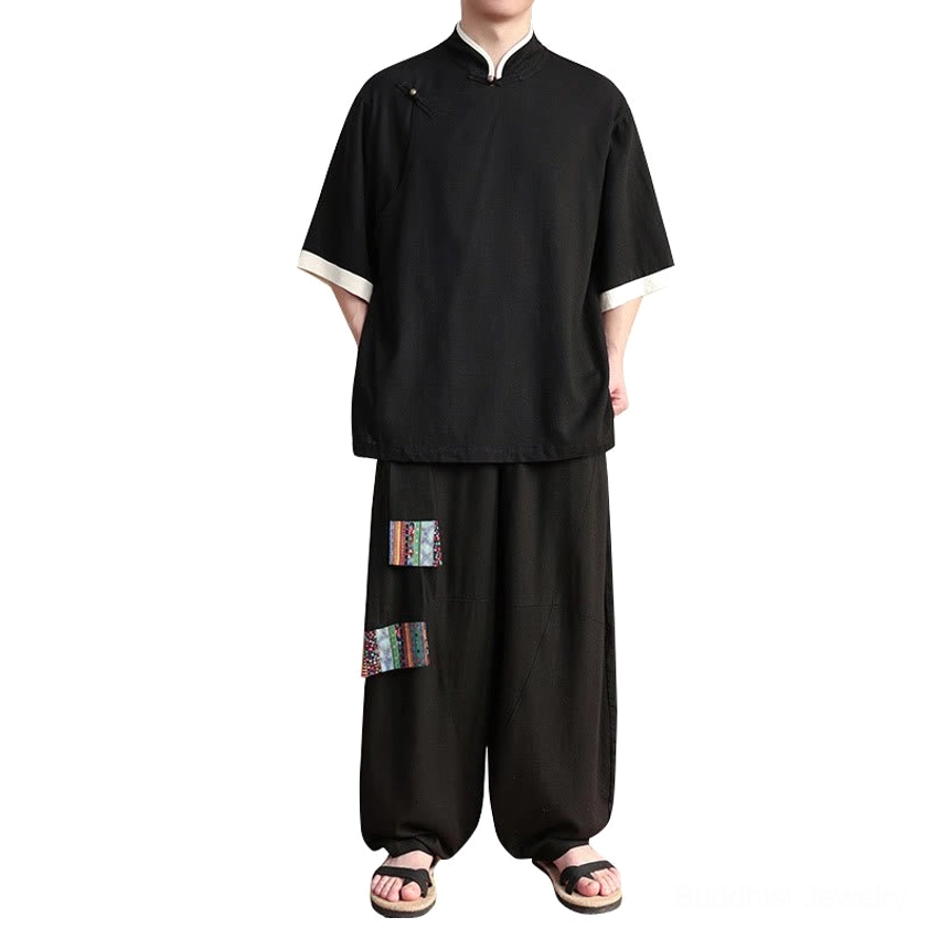 Flat lay view of black men's meditation suit on white background showing frog button top and ethnic pants patches