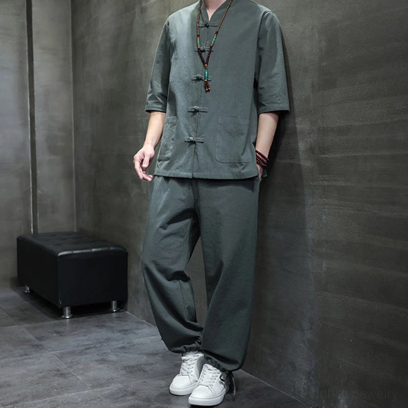 Men's Buddhist meditation cotton linen tang suit set side view with hand in pants pocket, showing dark gray-green fabric