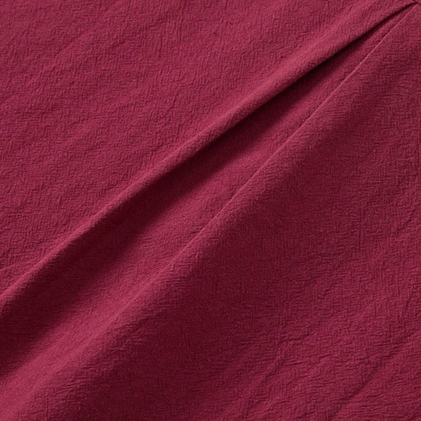 Burgundy woven fabric texture close-up of men's meditation clothing, subtle grid weave pattern