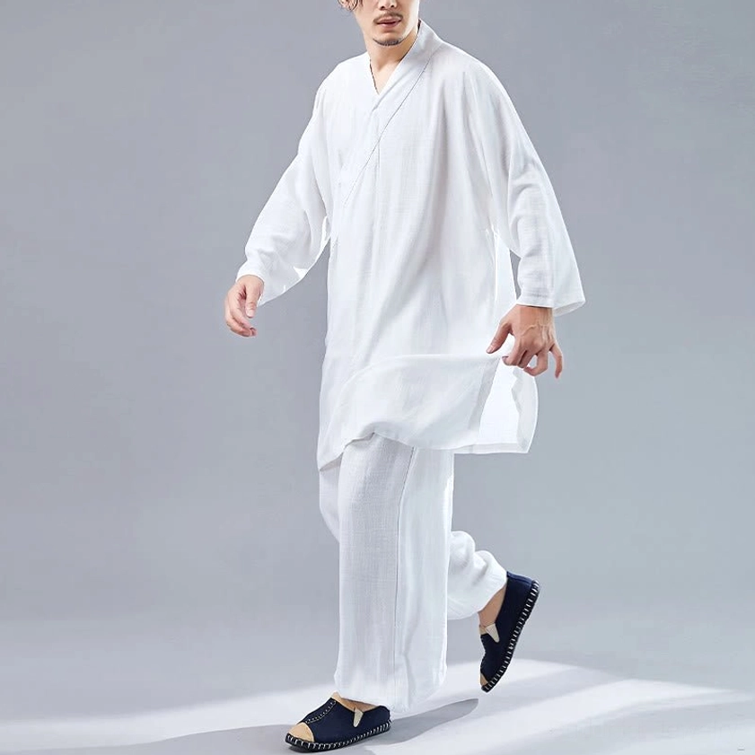 Man walking in white cotton-linen meditation uniform showing side-split hem and relaxed fit