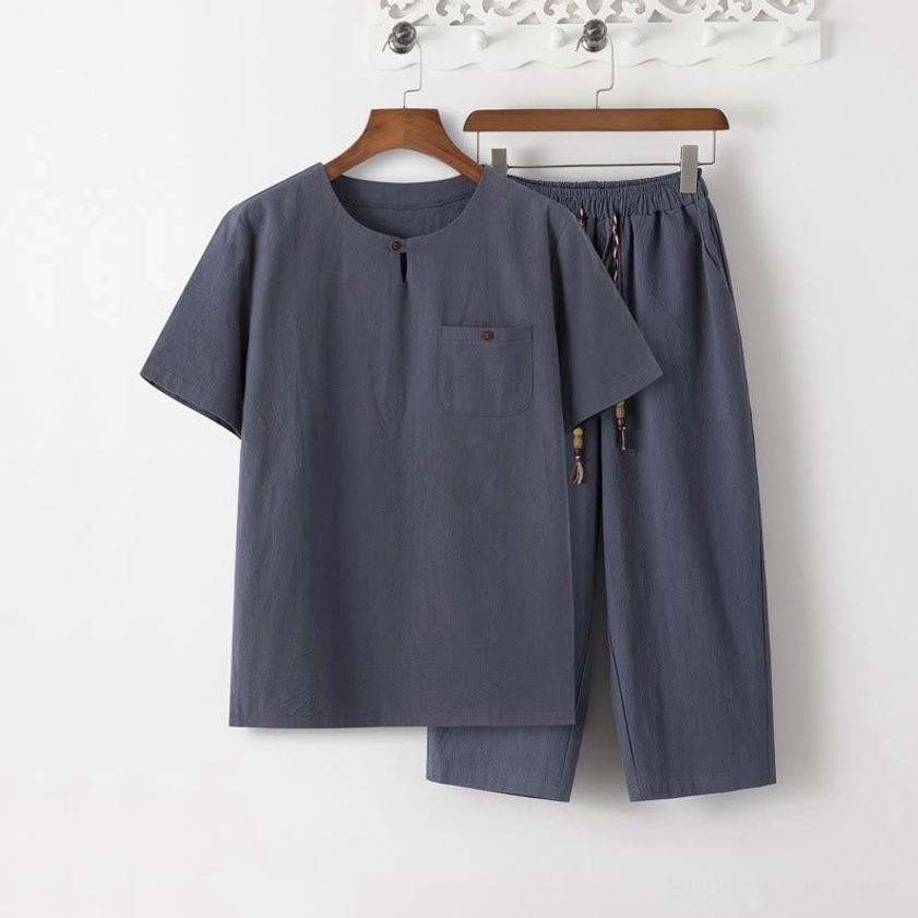 Buddhist meditation clothing set for men - dark gray cotton linen suit displayed on hanger, front view showing short sleeve shirt with decorative button and matching cropped pants with drawstring