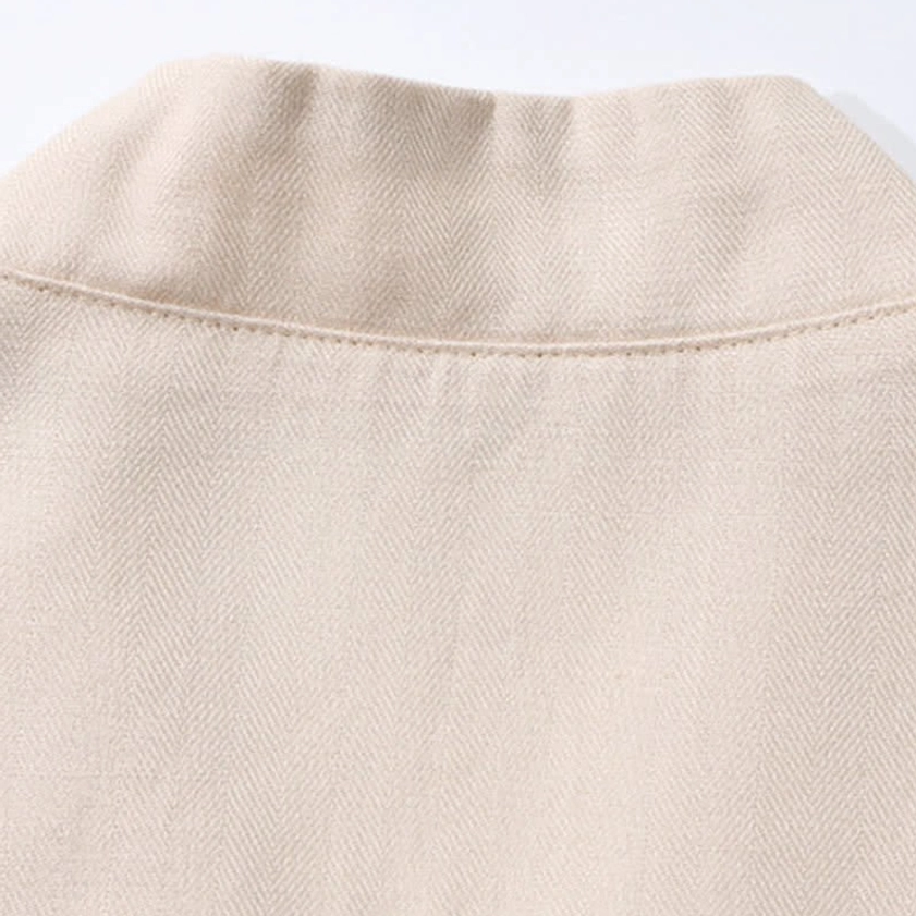 Detailed view of cream meditation shirt fabric weave and hem finishing seams on men's zen clothing set