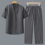 Dark gray men's meditation shirt and pants set flat lay front view with V-neck short sleeves and drawstring waist