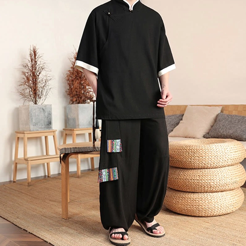 Black meditation wear set worn on mannequin showing stand collar detail and ethnic patches on pants