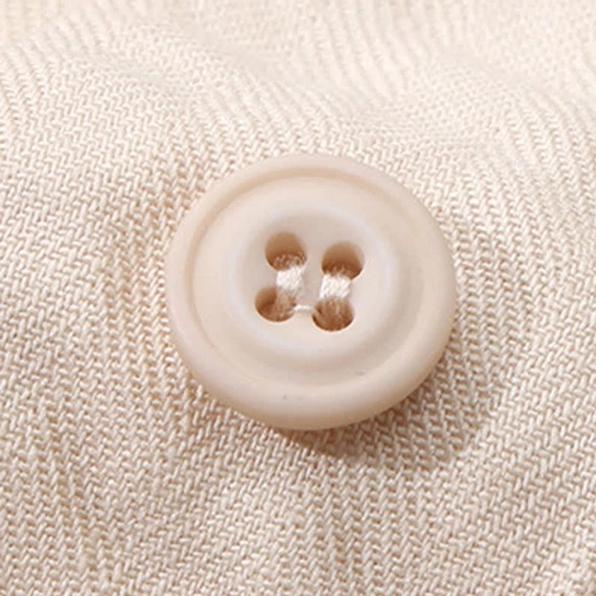 Four-hole round cream button and linen-cotton woven fabric texture detail of men's minimalist meditation shirt