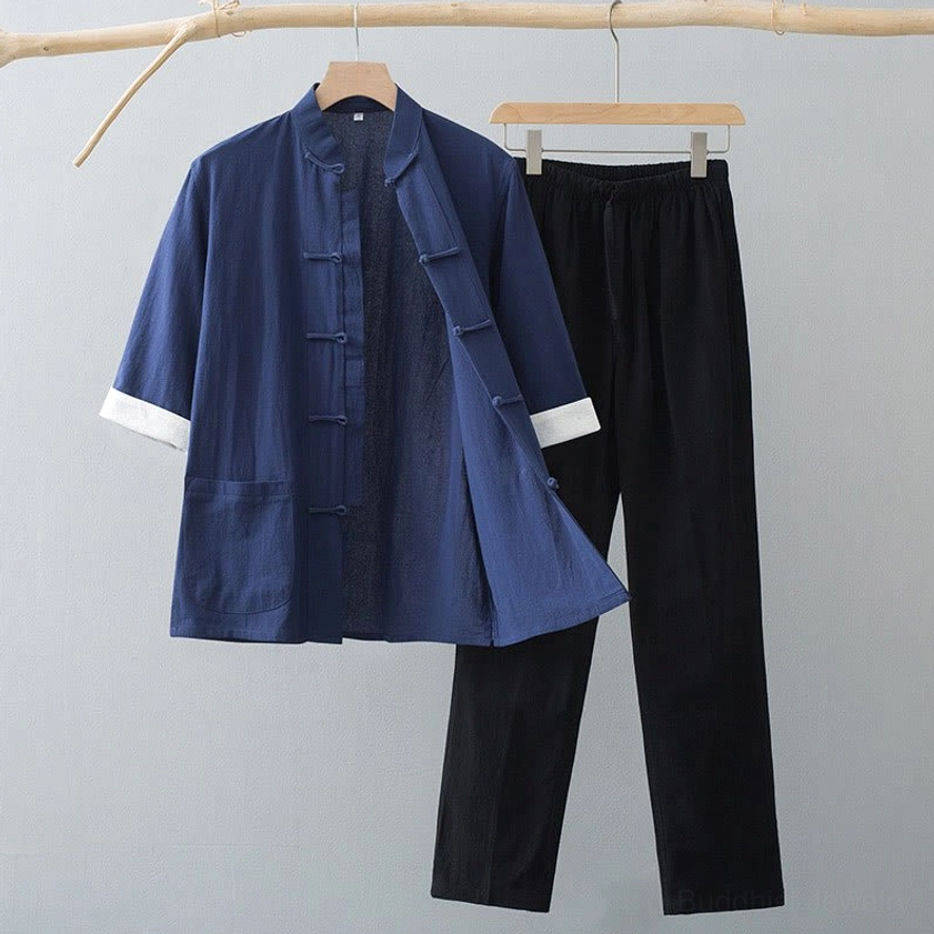 Men's Tang suit in navy blue top with black pants, showing traditional frog button design and white sleeve cuffs on wooden hanger