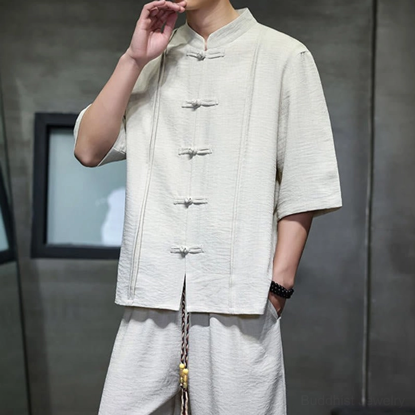 Men wearing Buddhist-inspired meditation suit with hand raised showing mandarin collar and frog buttons