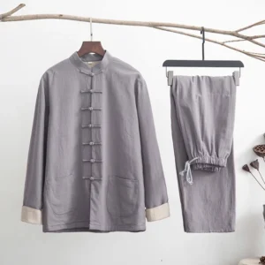 Men's linen zen tang suit set in light gray with traditional frog buttons and white contrast cuffs, displayed on side view with dry branch meditation props