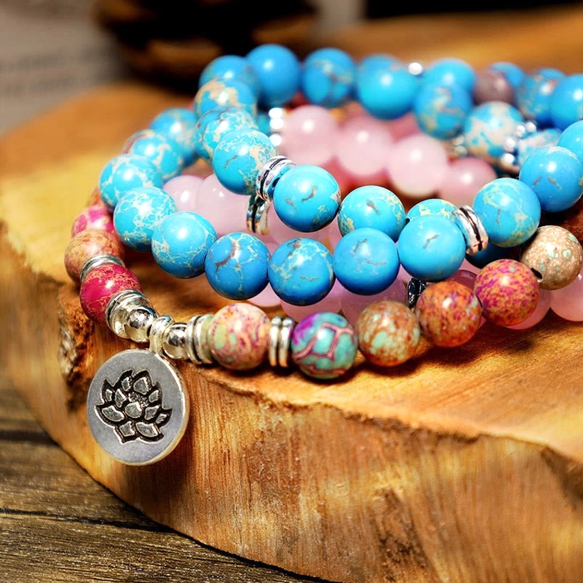 Macro detail shot of turquoise blue and pink natural stone beads with intricate lotus metal pendant - Miano mala craftsmanship
