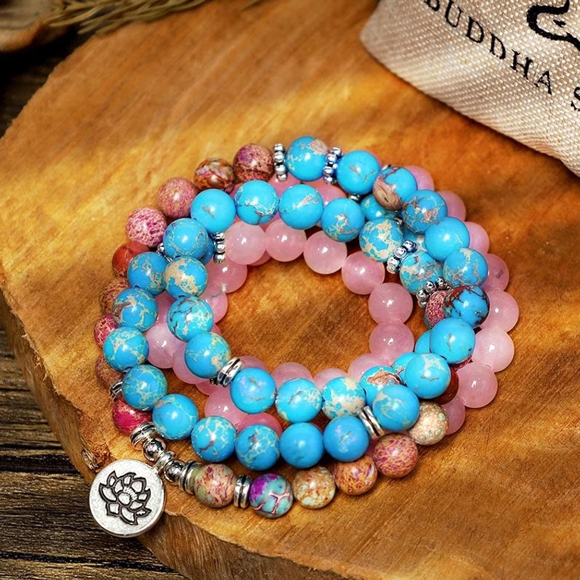 Purple and pink Miano 108 bead mala set on wooden table with branded spiritual pouch - authentic Buddhist prayer beads