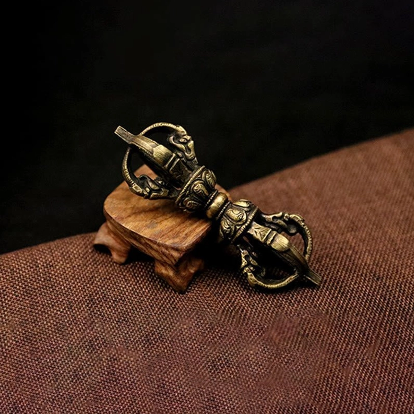 Mini bronze five-prong vajra dorje with aged patina and detailed engraved religious motifs, compact meditation size