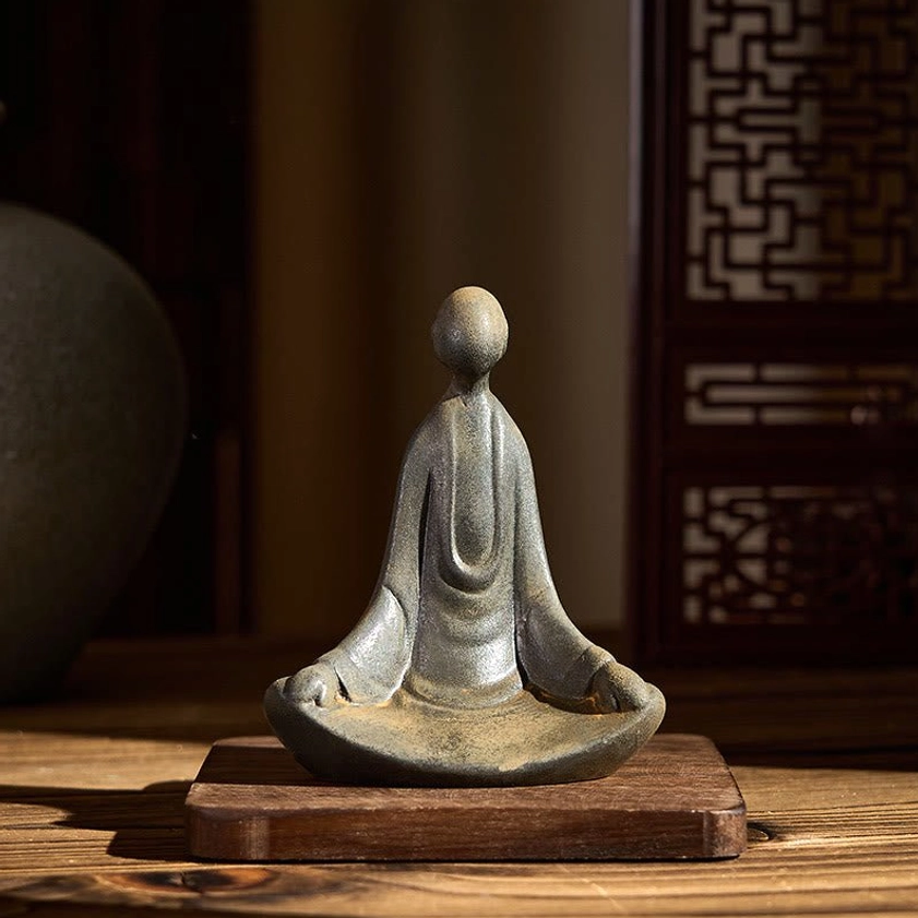 Compact handmade Buddha statue on wooden coaster with lattice window backdrop spiritual decor display